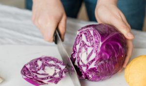 woman slicing purple vegetable